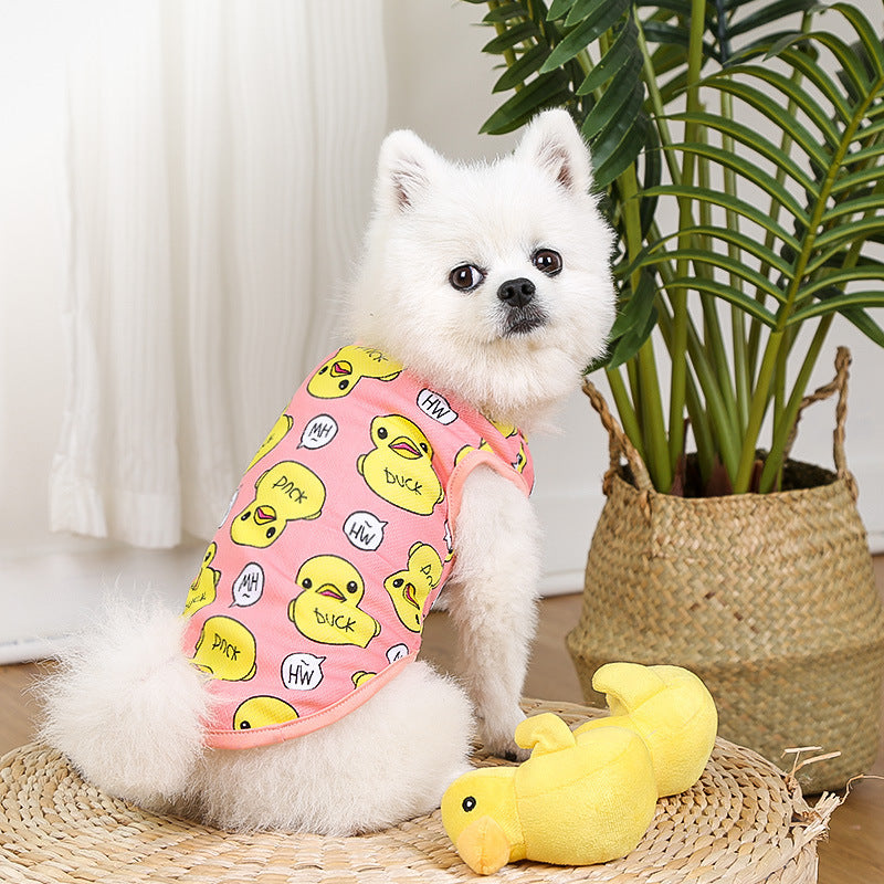 Chien en t-shirt en coton avec motif de canard, jouet en forme de canard à côté dans un environnement intérieur.