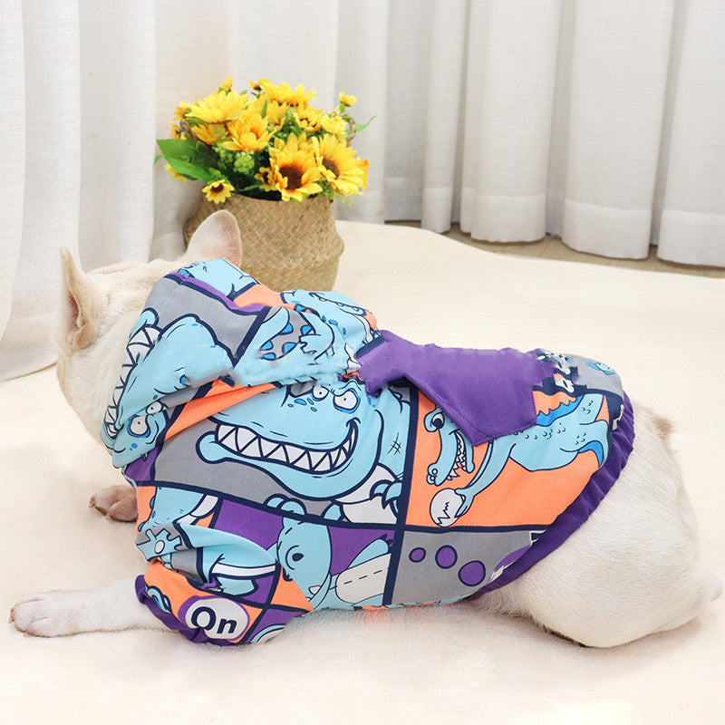 Chien avec un pull à capuche polaire au design de dinosaure, parfait pour garder votre animal au chaud.