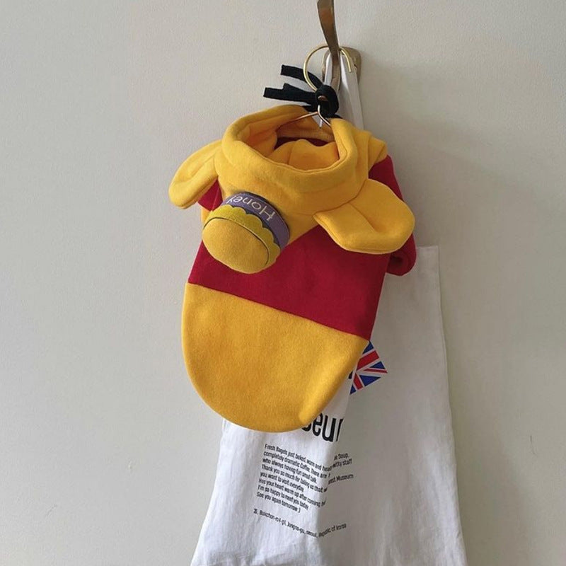 Vêtement color block pour chien jaune et rouge, style Winnie l'Ourson, suspendu à un sac.