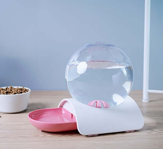 Fontaine à boire automatique pour animaux, design compact avec réservoir d'eau et bol en rose et blanc.