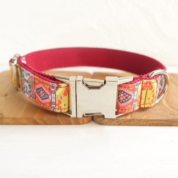 Collier de chien bohème avec clochette en coton biologique, design coloré et durable sur un support en bois.