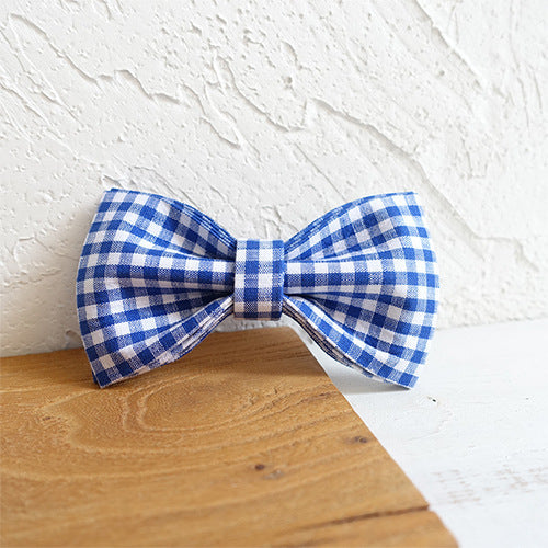 Noeud papillon en polyester bleu à carreaux pour chien sur fond en bois.