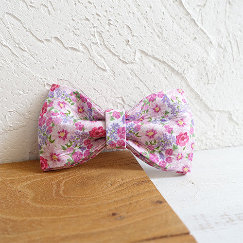 Nœud papillon en polyester à fleurs pour chien sur fond en bois, ajoutant une touche de style à votre compagnon.