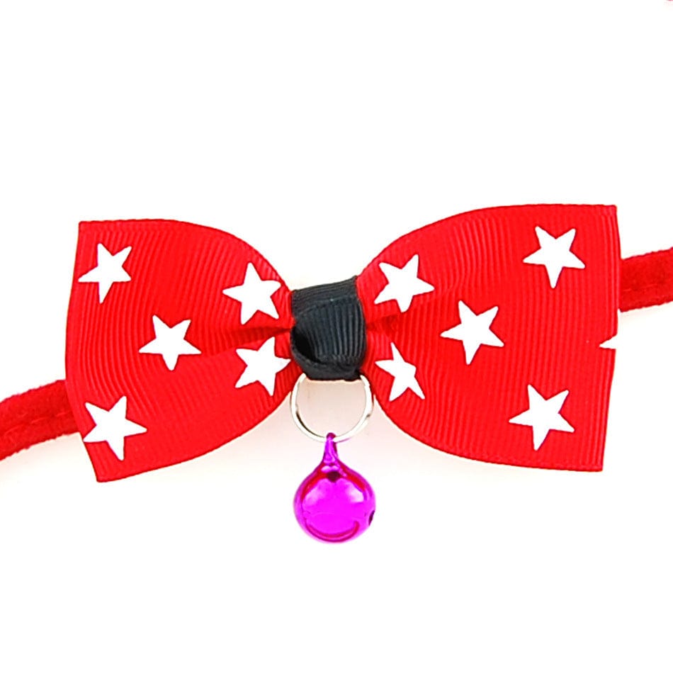 Nœud papillon rouge avec étoiles blanches et cloche, accessoire stylé pour chiens et chats.