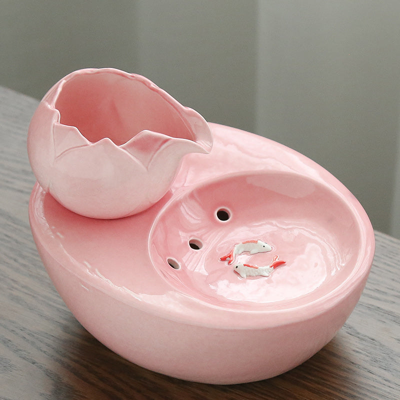 Fontaine à eau pour chat en rose, design élégant avec un effet de mouvement pour encourager l'hydratation.