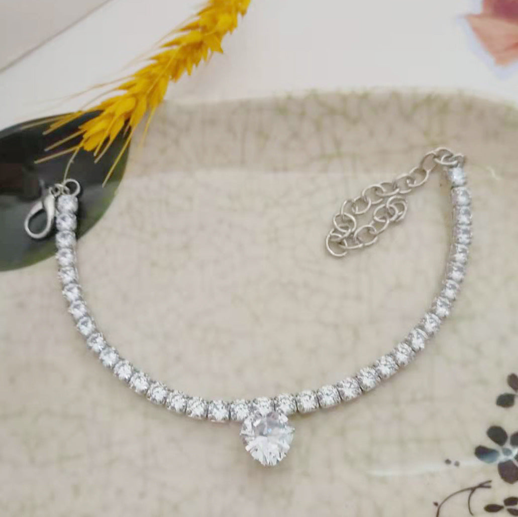 Collier en rhinestones en forme de cœur pour animaux, brillant avec pierres étincelantes sur fond élégant.
