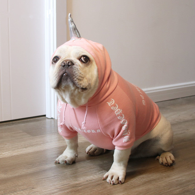 Chien dans un pull en coton rose avec capuche, parfait pour Halloween et les promenades décontractées.