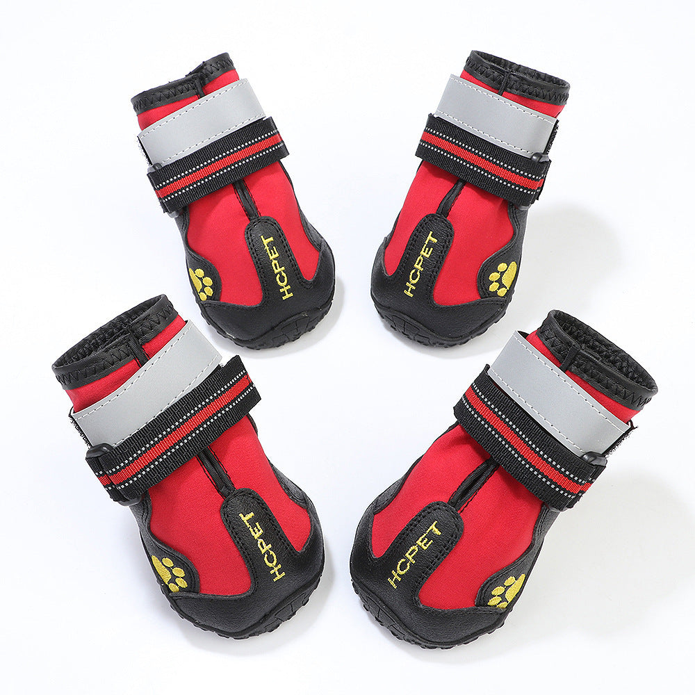 Chaussures imperméables pour chiens rouges avec bandes réfléchissantes, conçues pour protéger les pattes des intempéries.