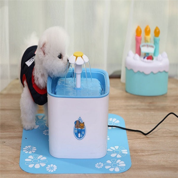 Distributeur d'eau automatique pour animaux, avec un petit chien qui s'hydrate à la fontaine sur un tapis.