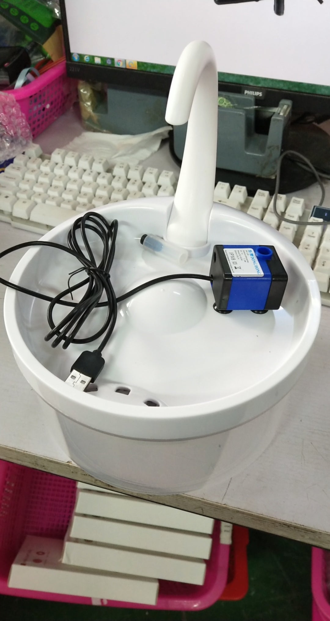 Fontaine à eau automatique pour animaux avec système de filtration et robinet imitant un écoulement naturel.