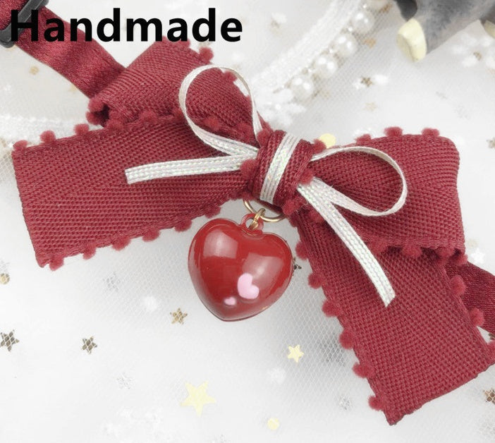Collier fait main avec un nœud en tissu rouge et un pendentif en forme de cœur pour chiens et chats.