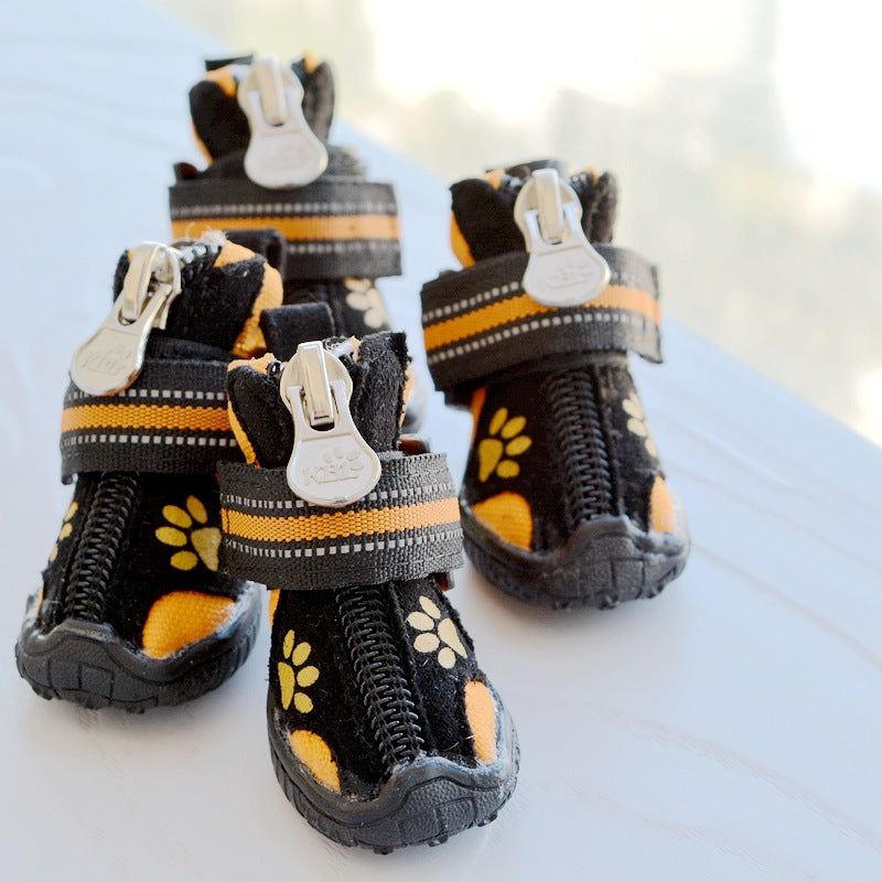 Chaussures en suède noires et oranges pour chiens, confort et style avec pattes imprimées.