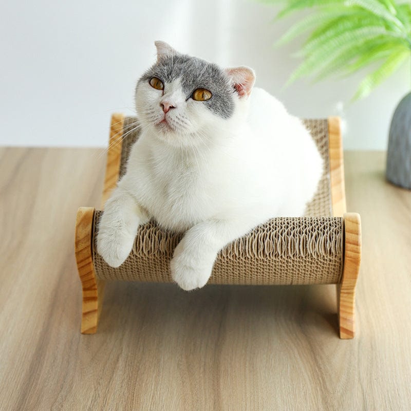 Chat relaxant sur un aiguiseur de griffes en jouet, fabriqué en papier ondulé et bois de pin.