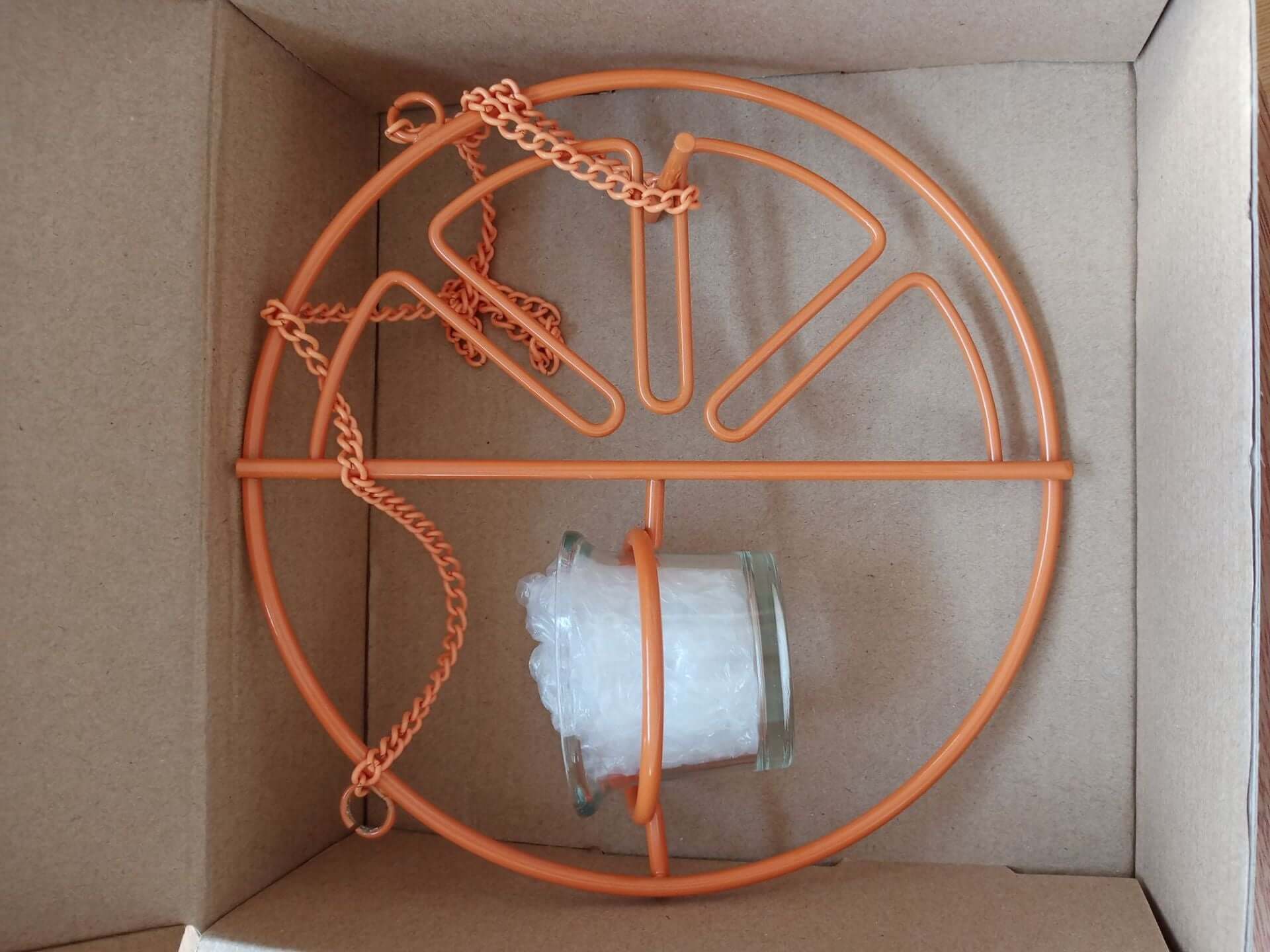 Distributeur d'eau et de nourriture pour oiseaux en plein air, design orange, dans sa boîte.