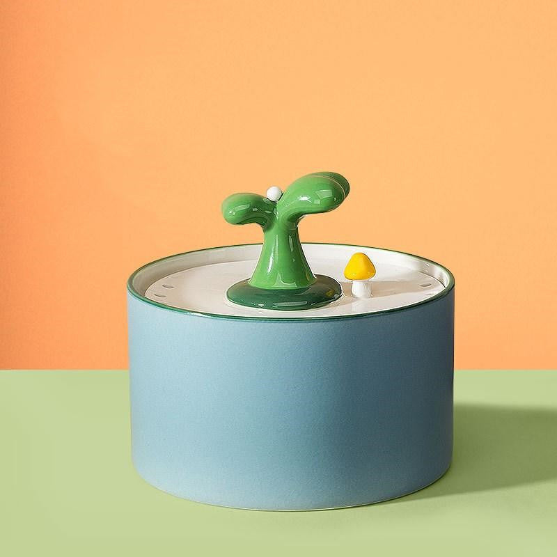 Fontaine à boire automatique en céramique pour chats, design moderne avec arbre vert.