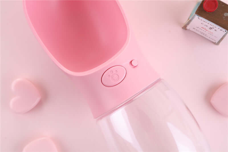 Fontaine à boire portable rose pour chiens et chats avec bouton de contrôle, design moderne et pratique.