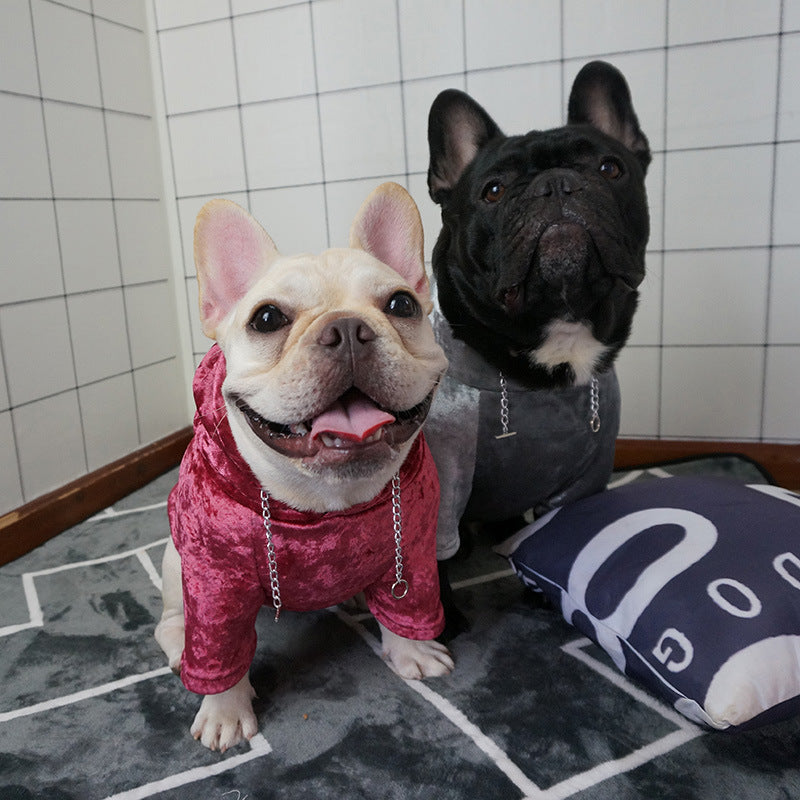 Deux chiens français portant des pulls à capuche douillets en velours, colorés en rouge et gris.