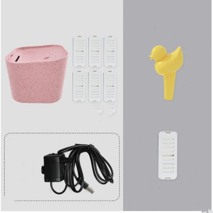 Distributeur d'eau automatique pour chats avec accessoires: base rose, accessoires blancs, et un oiseau jaune décoratif.