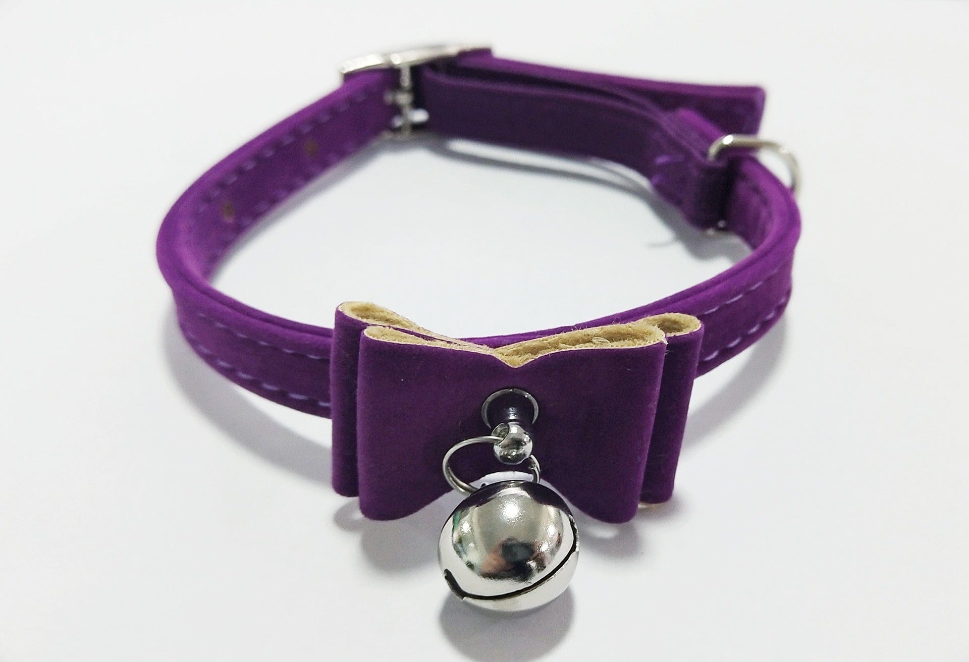 Collier pour chat violet avec cloche et nœud en tissu doux, alliant style et sécurité.