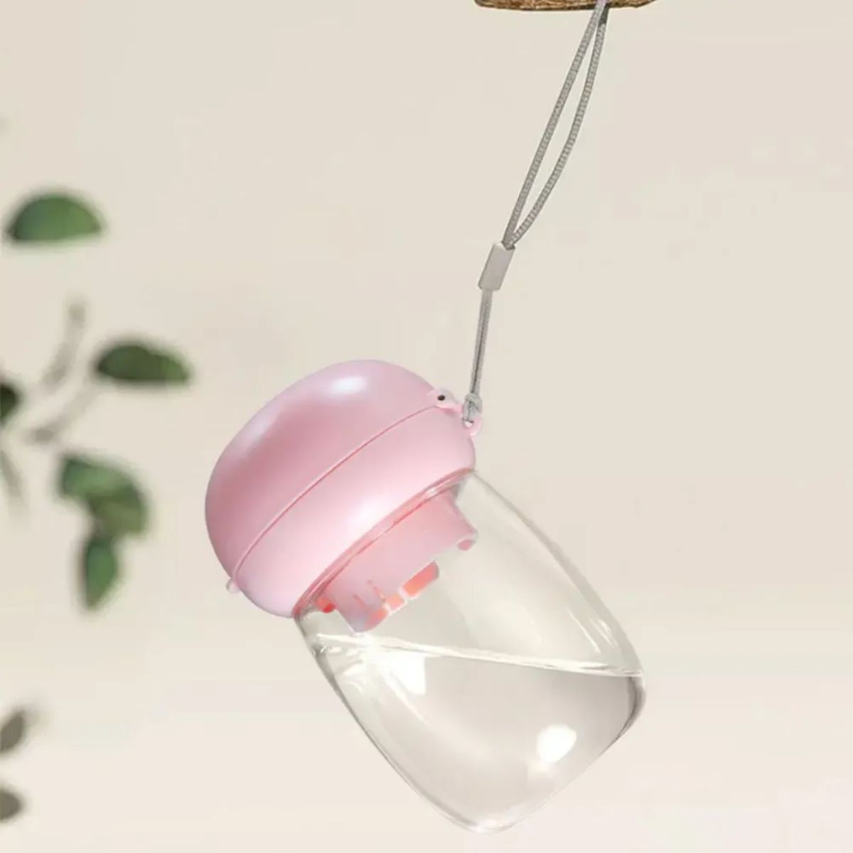 Gourde portable rose pour animaux de compagnie avec lanière, idéale pour hydrater chien ou chat lors des sorties.