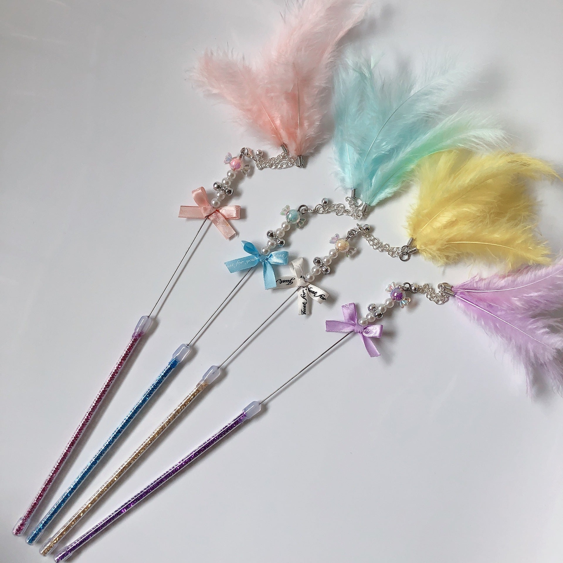 Bâton à lancer fait main pour chat avec plumes colorées bleu, rose, vert et jaune, idéal pour le jeu interactif.