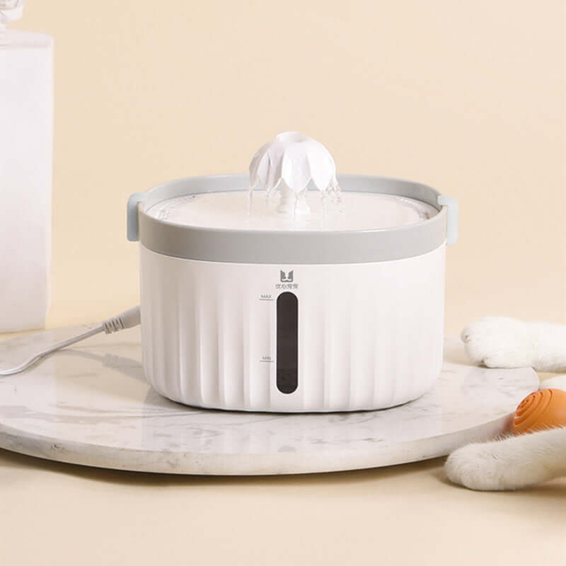 Distributeur d'eau pour chat blanc sur marbre, idéal pour l'hydratation des animaux de compagnie.