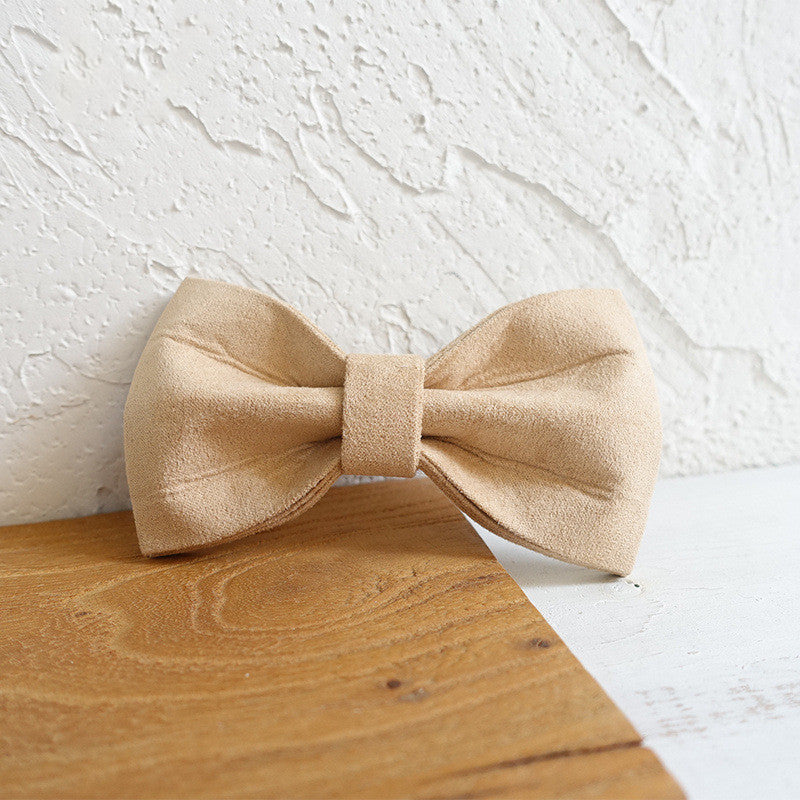 Nœud papillon en polyester fait main pour chiens, couleur beige, sur une surface en bois.