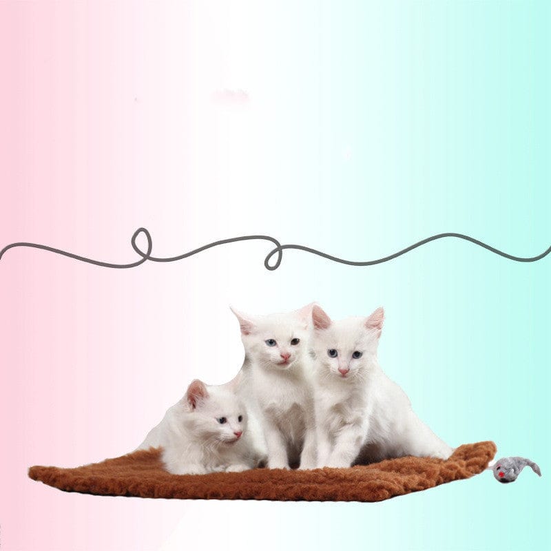 Trois chatons blancs se reposant sur un tapis en chanvre, avec un jouet souris à côté.
