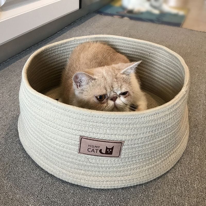 Chat confortablement installé dans une litière en corde de coton fait main, douce et respectueuse de l'environnement.