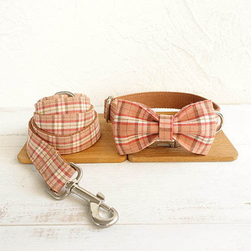 Laisse pour chien avec nœud papillon en tissu à carreaux, sur support en bois, élégante et confortable.
