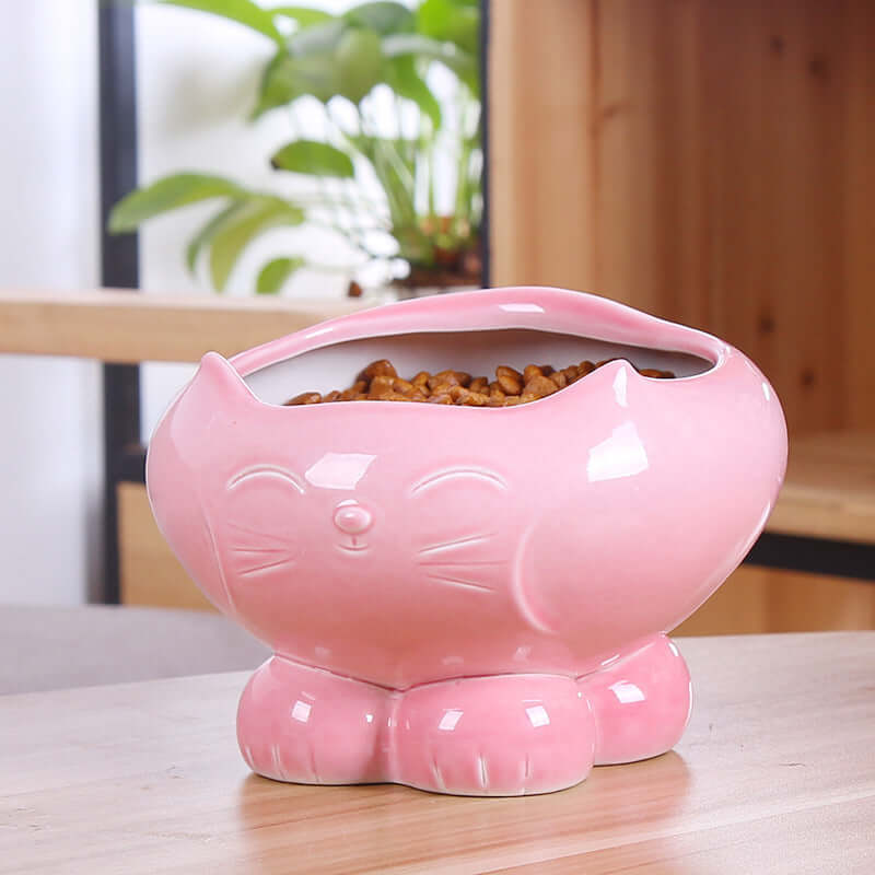 Distributeur de nourriture pour chat en céramique rose avec visage de chat, parfait pour nourrir votre félin.