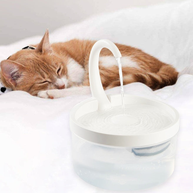 Fontaine à eau automatique pour animaux avec un design innovant, près d'un chat endormi.
