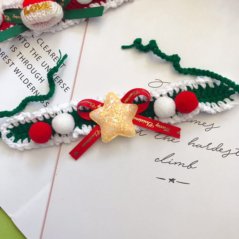 Collier pour animaux en laine avec décoration festive, pompons rouges et étoile dorée, sur une surface en papier.