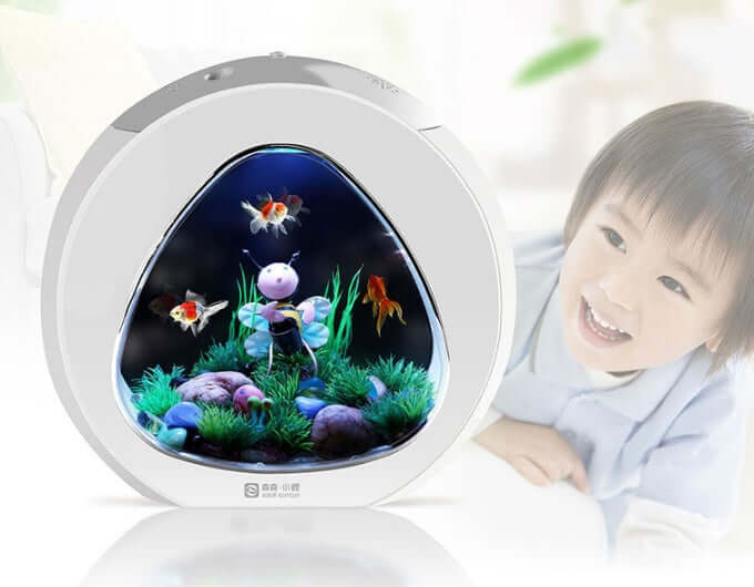 AquaDesign Aquarium de Bureau with colorful fish, surrounded by greenery, next to a smiling child.