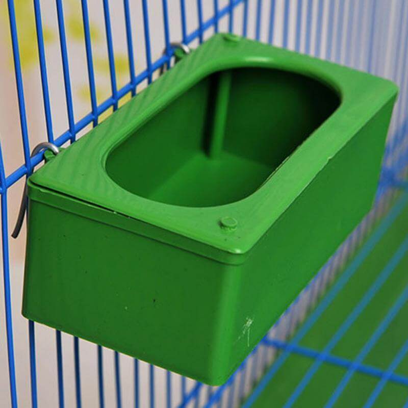 Conteneur de nourriture pour oiseaux étanche, vert, fixé à une cage, idéal pour nourrir les oiseaux.