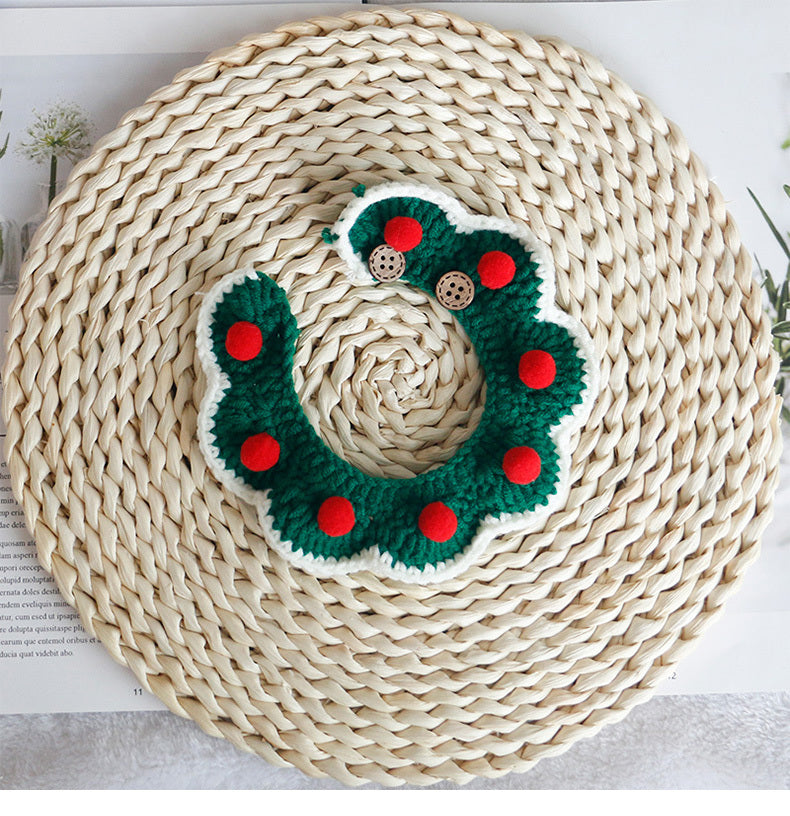 Écharpe de Noël en tricot vert avec pompons rouges, présentée sur un dessous de plat tressé en osier.