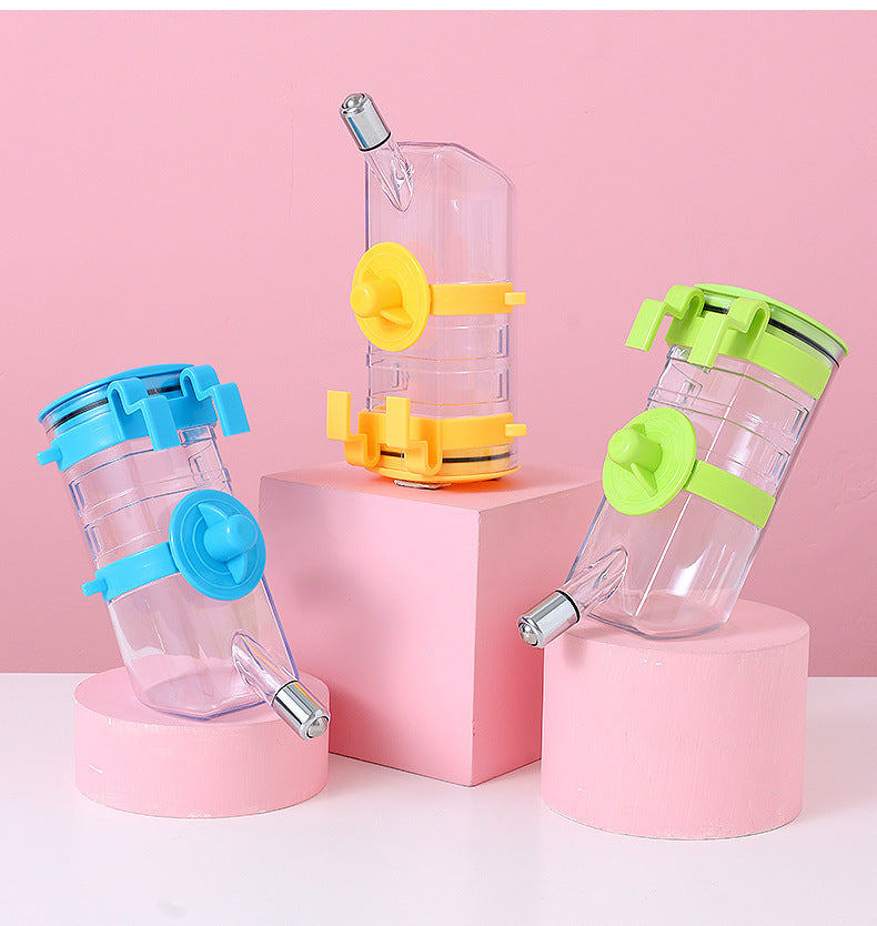 Distributeur d'eau pour chien sans goutte en couleur transparente, bleu, vert et jaune sur fond rose.
