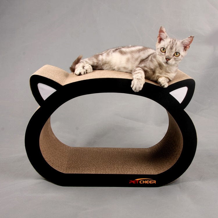 Chat se relaxant sur une planche à gratter en forme de tête de chat, conçue pour les griffes des félins.