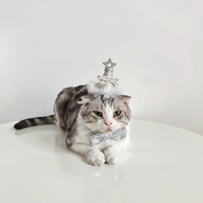 Chat portant un chapeau d'anniversaire en sequins argentés avec un nœud, célébrant un moment festif.
