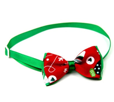 Nœud papillon de Noël pour chiens et chats, design festif avec motifs joyeux sur fond rouge.