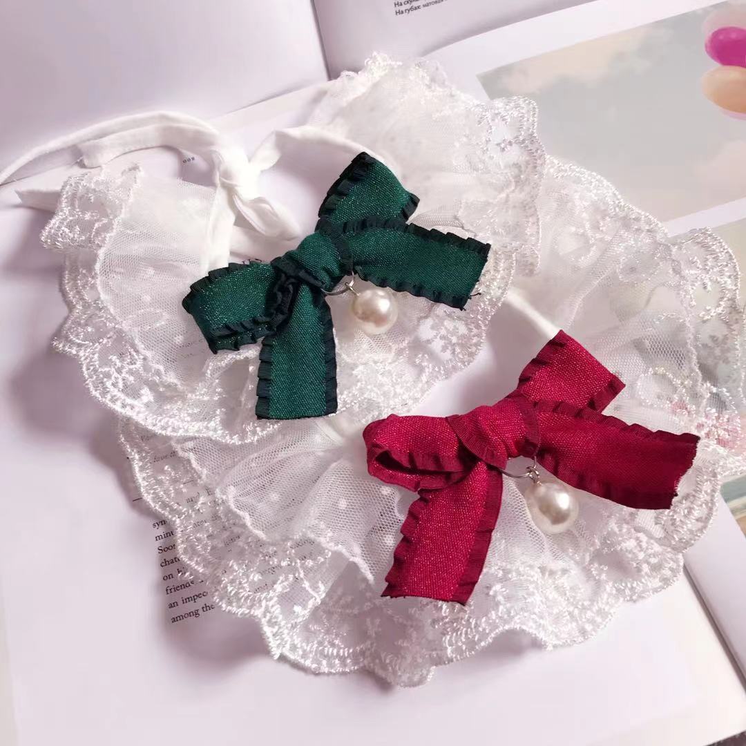 Bavoir en dentelle pour animaux avec nœuds vert et rouge, idéal pour chiens et chats, ajoutant style et protection.