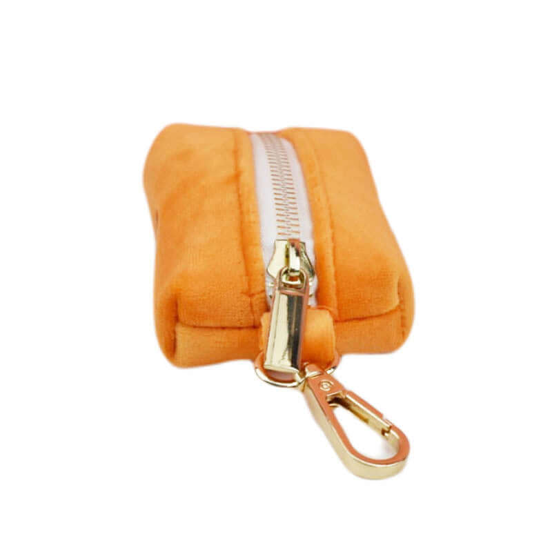 Porte clés en velours orange avec fermeture éclair et clip en métal.