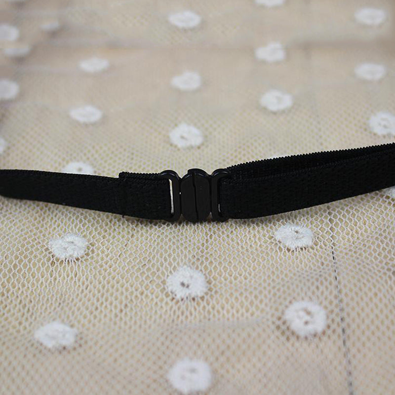 Fermeture à clip noir sur fond de tissu à pois blancs, idéal pour accessoires de mode.
