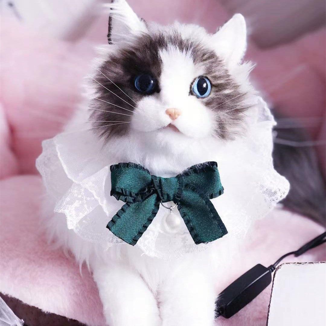 Bavoir en dentelle blanc avec un nœud vert sur un chat en peluche, ajoutant un style élégant pour animaux.