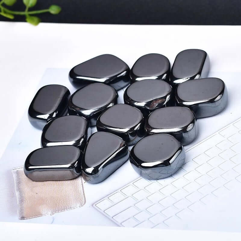 Ornements en pierre brute d'hématite brésilienne naturelle sur une surface blanche, offrant une touche moderne.