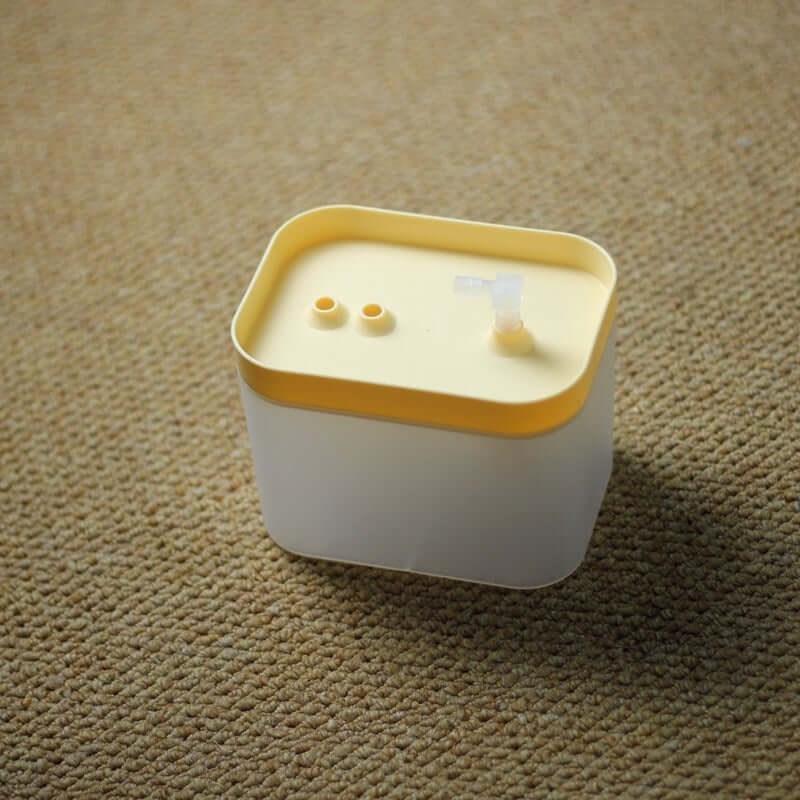 Distributeur automatique d'eau pour animaux avec couvercle jaune, conçu pour garder les animaux hydratés.