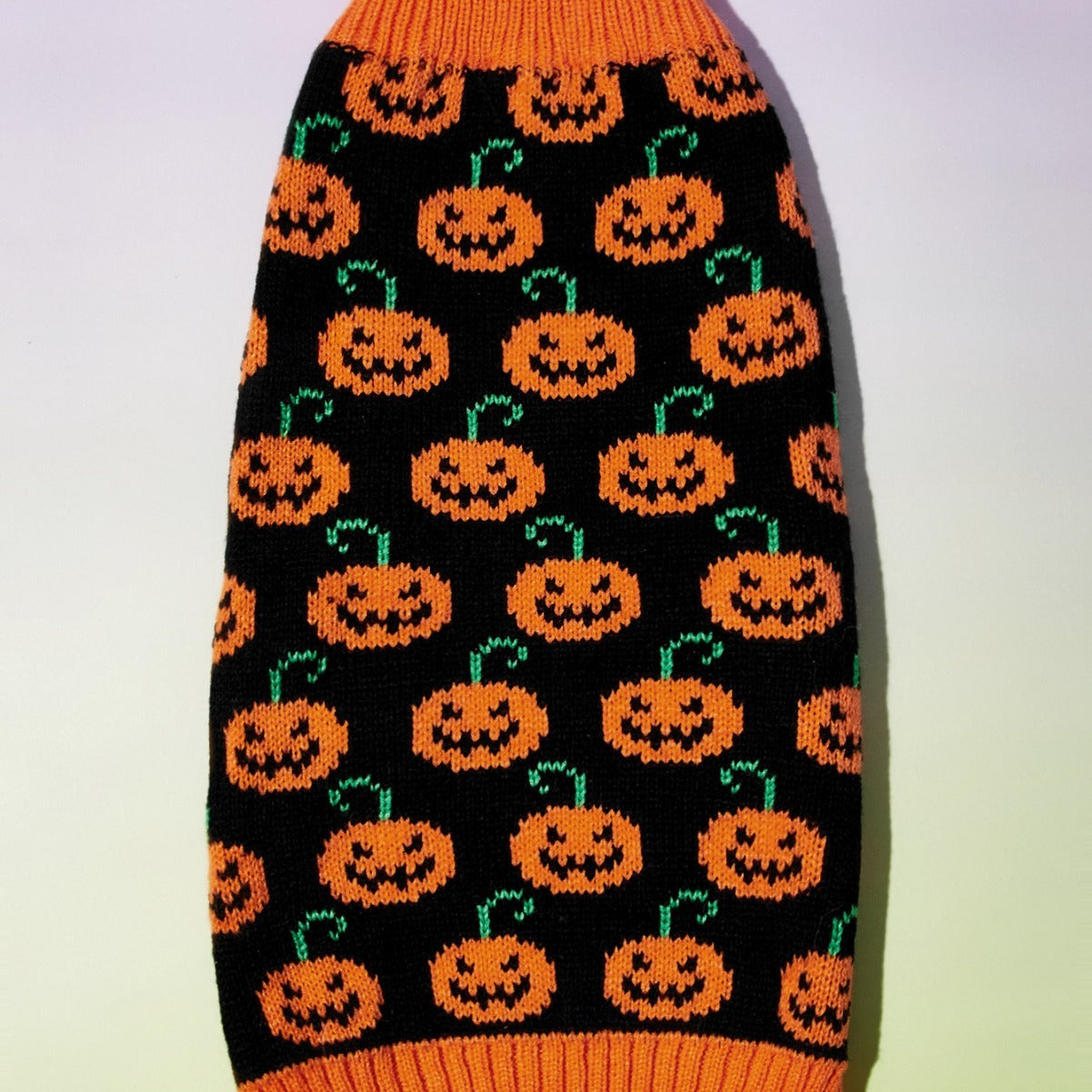 Pull pour chien noir avec motifs de citrouilles orange, parfait pour l'automne et l'hiver.