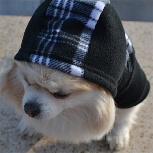 Chien portant un vêtement à capuche en fleece noir et blanc à carreaux pour l'hiver, offrant confort et style.