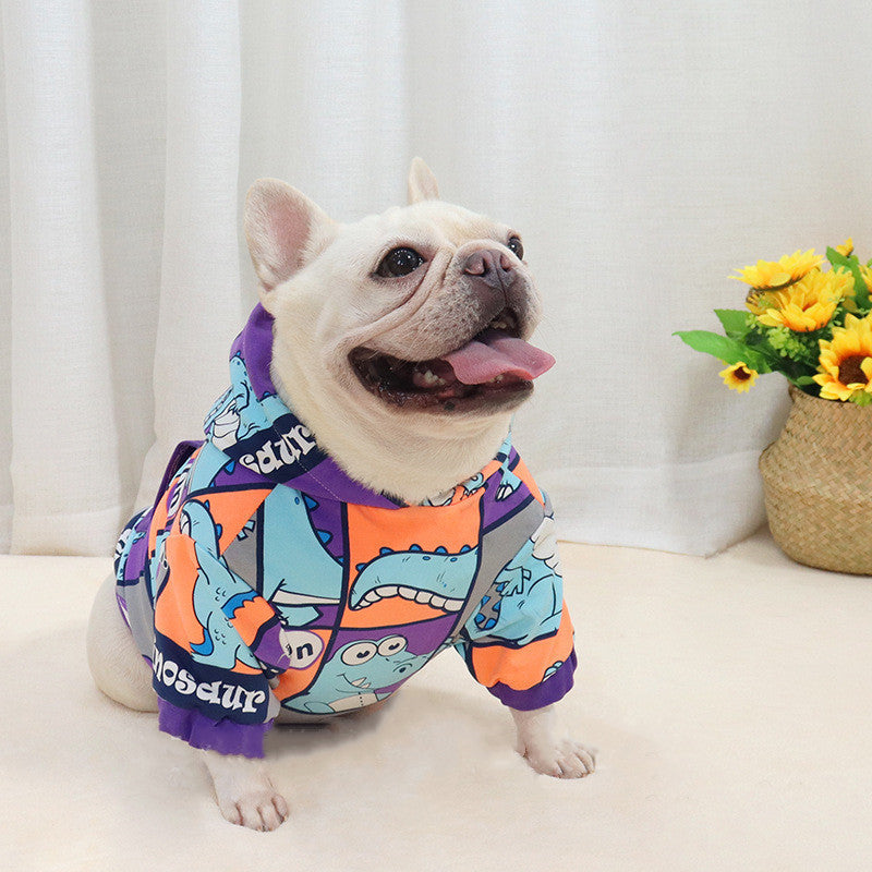 Chien portant un pull à capuche en polaire avec motifs de dinosaure, parfait pour les journées froides.