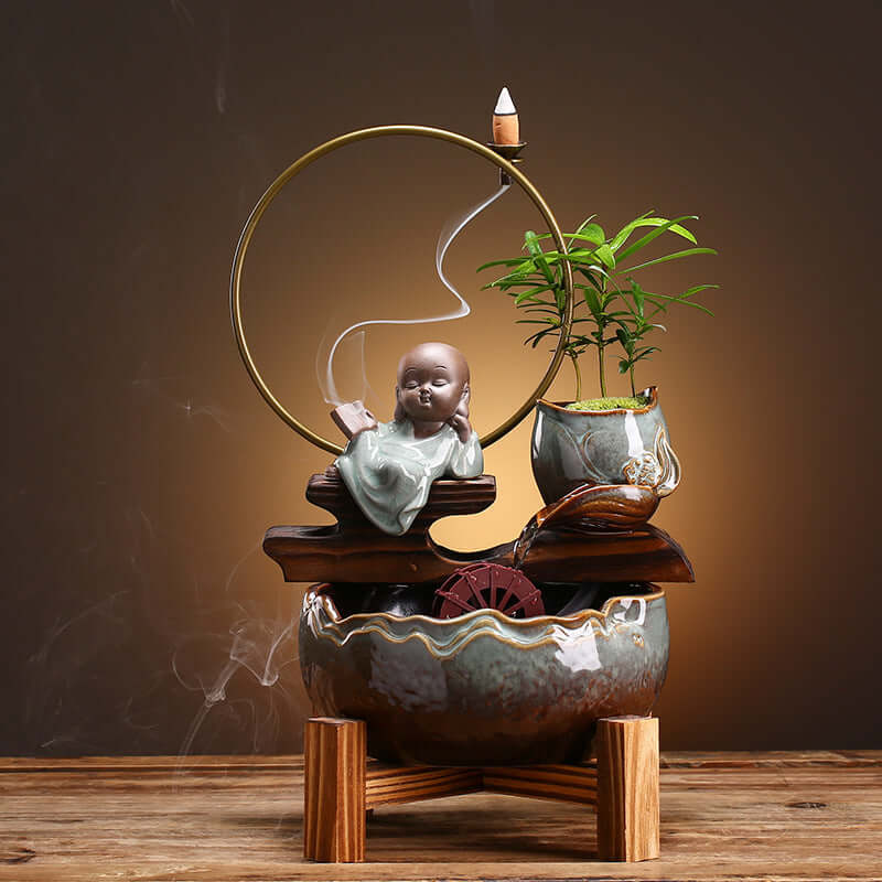 Élégant décor en céramique avec statue zen, plante et roue à eau, parfait pour l'intérieur.